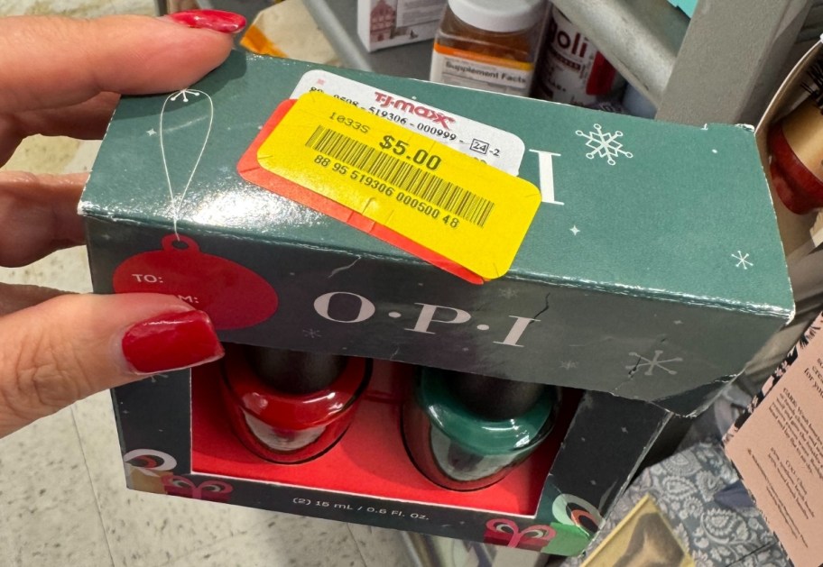 a womans hand holding aq 2 pack of nail color