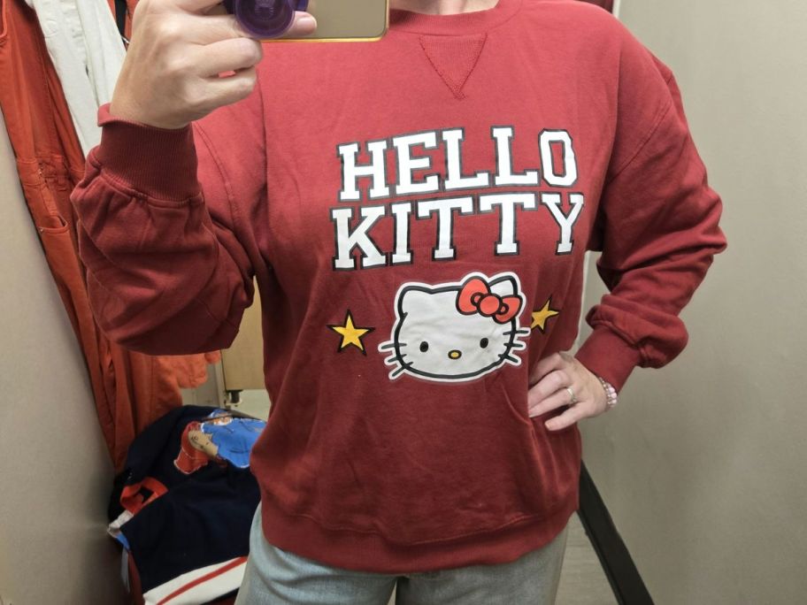 woman wearing red hello kitty sweatshirt in dressing room in store