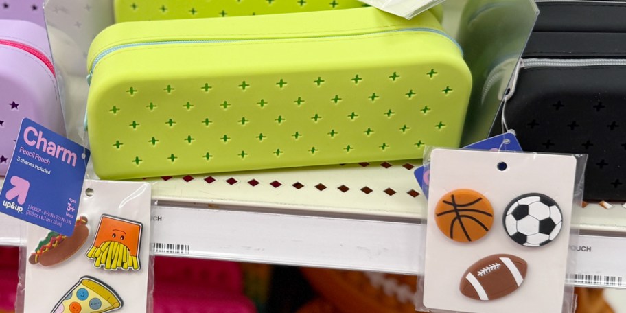 green pencil case with charms on shelf