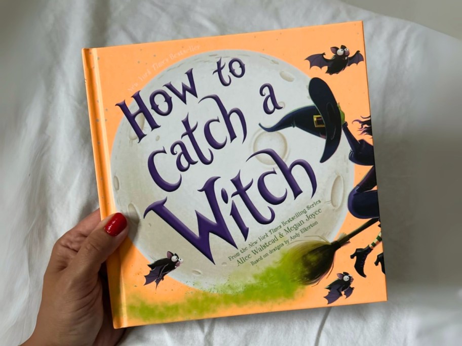 hand holding a hardcover How to Catch a Witch kids book