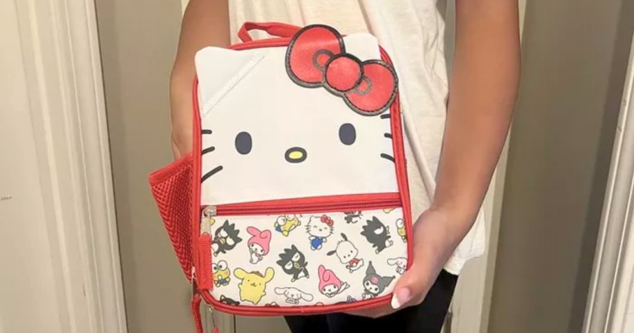girl holding hello kitty lunch box