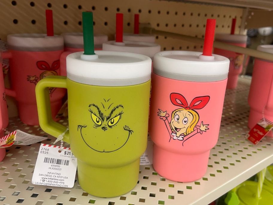 Several green and pink drink tumblers with the Grinch's face on them 