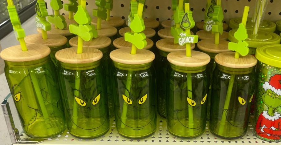 Several green drink tumbler with the Grinch's face on them 