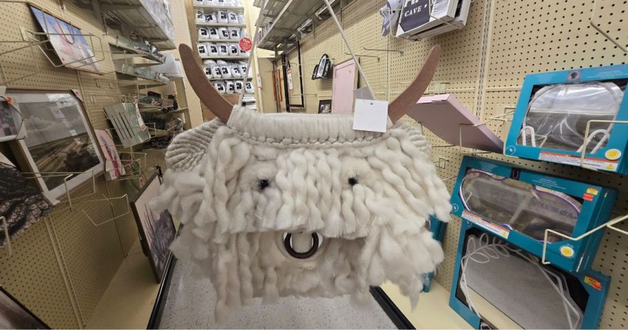 A smiling yarn yak wall hanging piece of artwork in a store