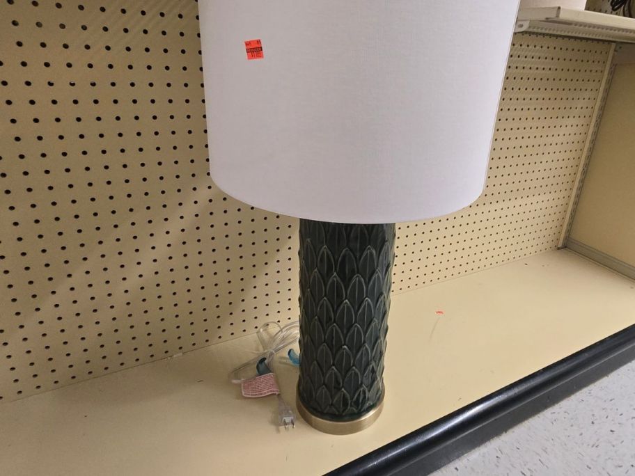 A large lamp with green leaves as a base
