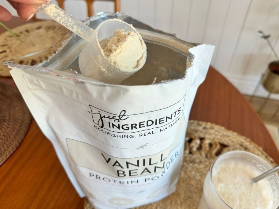 Hand scooping Just Ingredients Protein Powder from a large bag