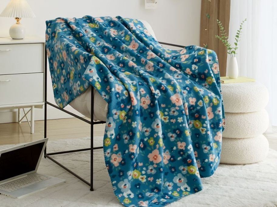 A floral printed fleece blanket on a chair