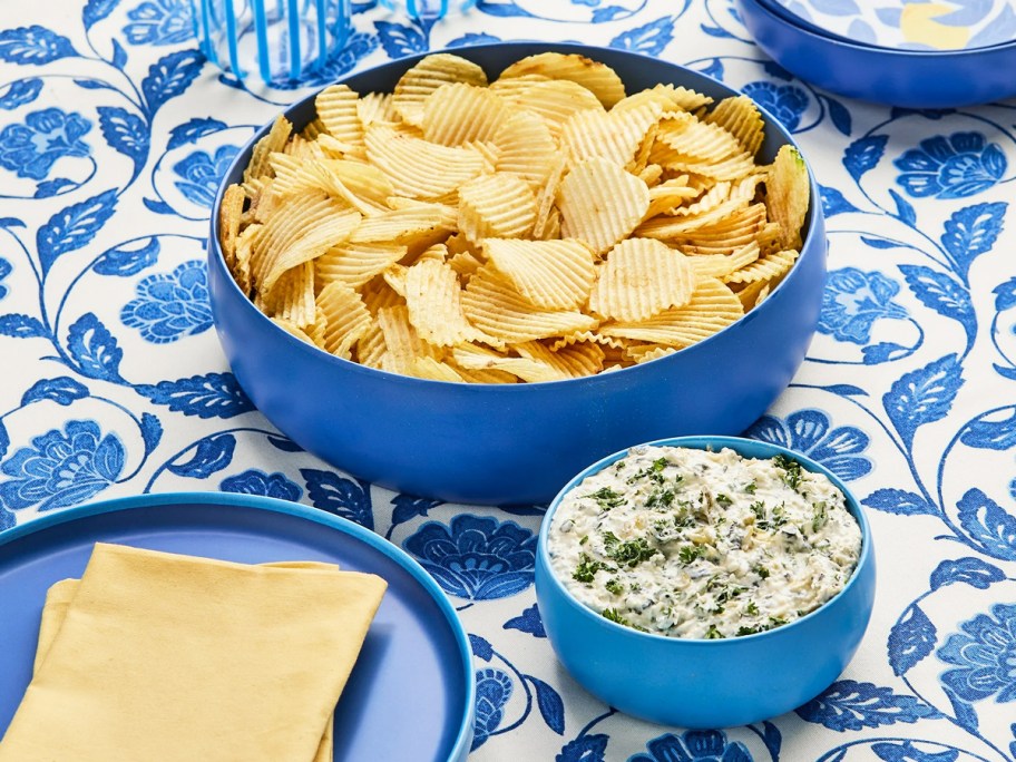 chips and dip in blue bowls on a table
