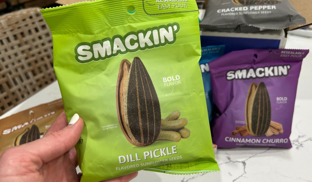 Women holding bag of smackin dill pickle, flavored jumbo sunflower seeds