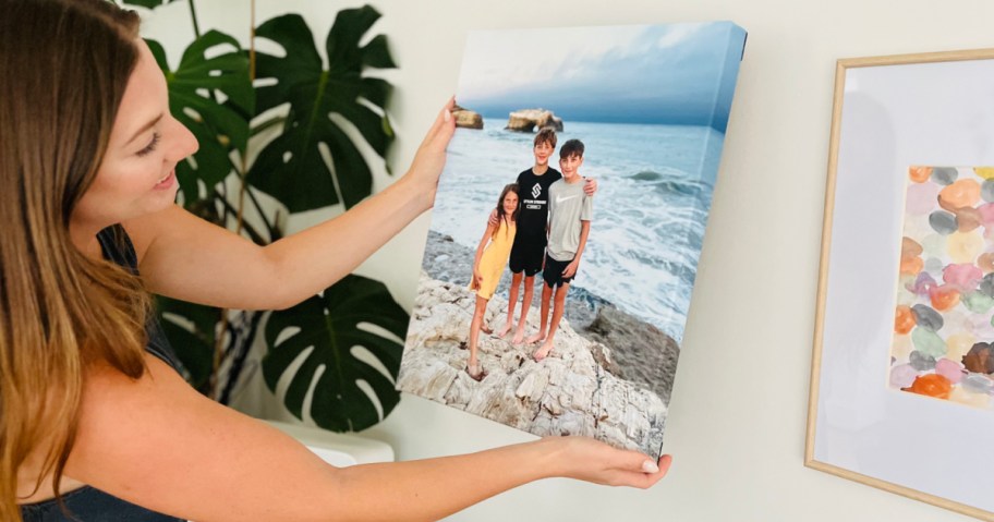 woman holding canvas print with kids on beach on wall 