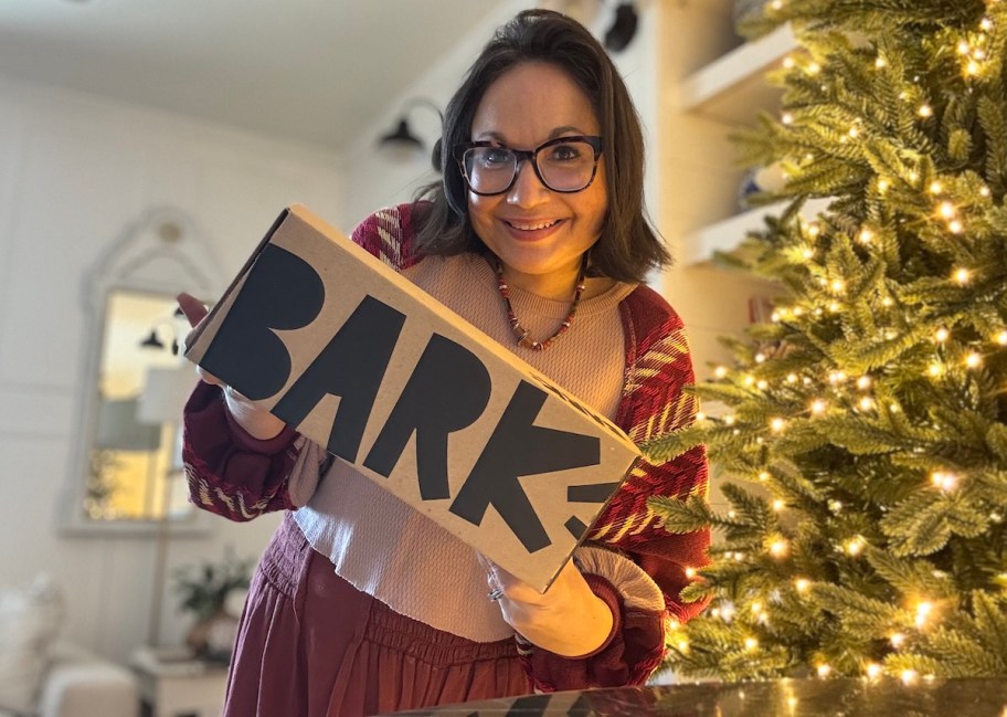 woman holding bark box in front of Christmas tree
