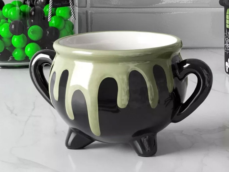 black and green cauldron mug on countertop 
