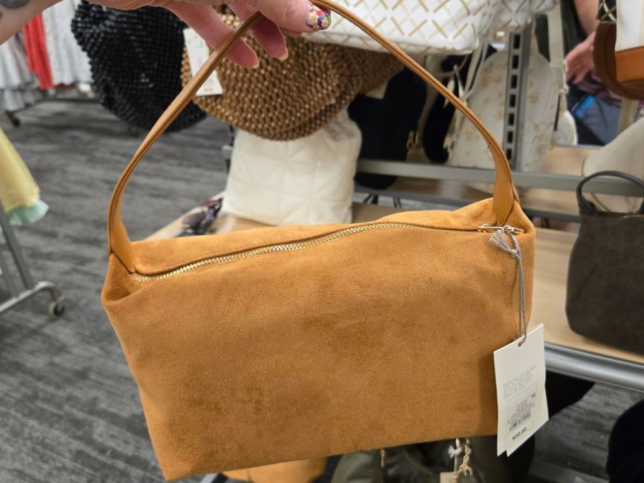 gold colored A New Day Soft Shoulder Bag in hand in store