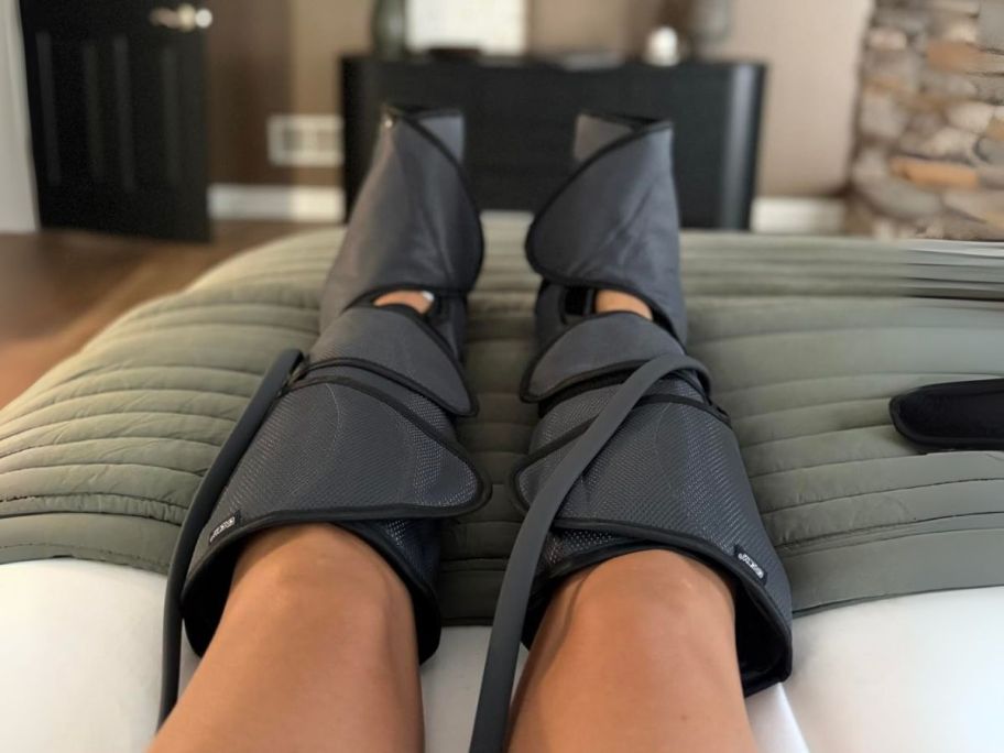 person wearing leg massagers in living room