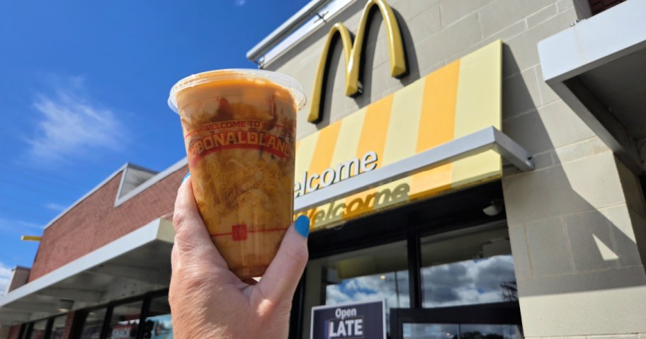mcdonald's latte in hand in front of signage
