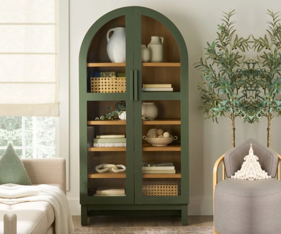green arch cabinet with decorations inside