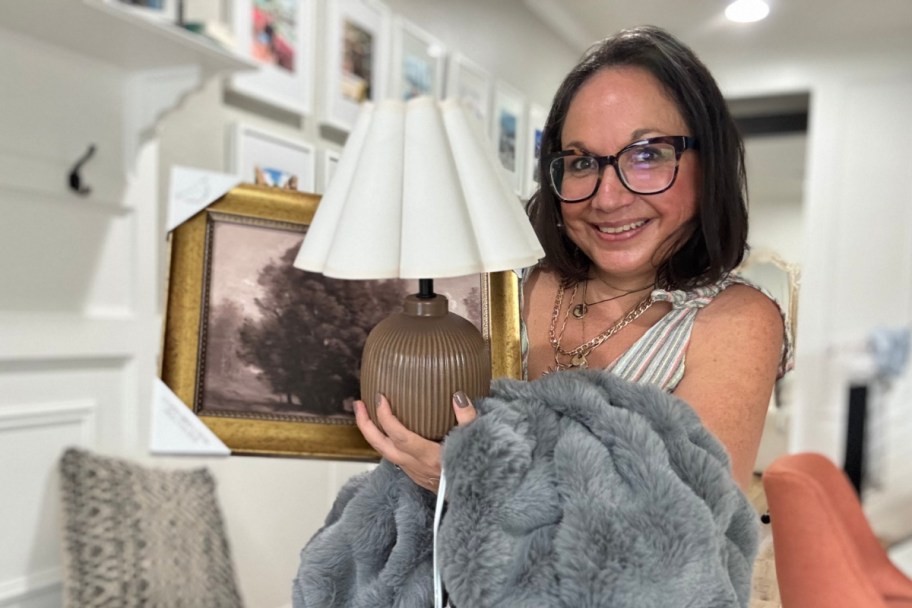woman holding lamp blanket and frame