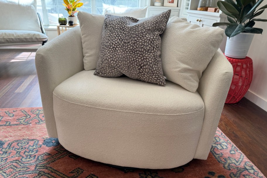 cream swivel barrel chair with pillows