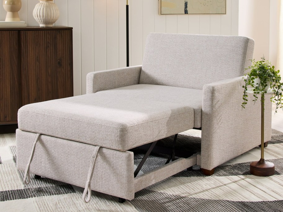 tan sofa sleeper chair next to plant and lamp