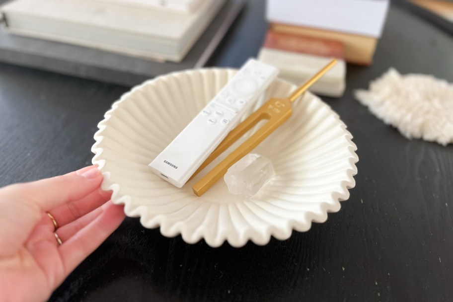 hand holding white ribbon bwol with remote in it