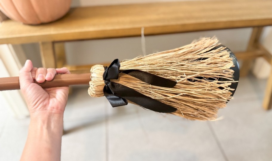 womans hand holding the broom