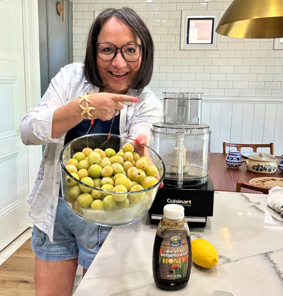 woman holding food processor with frozen grapes 