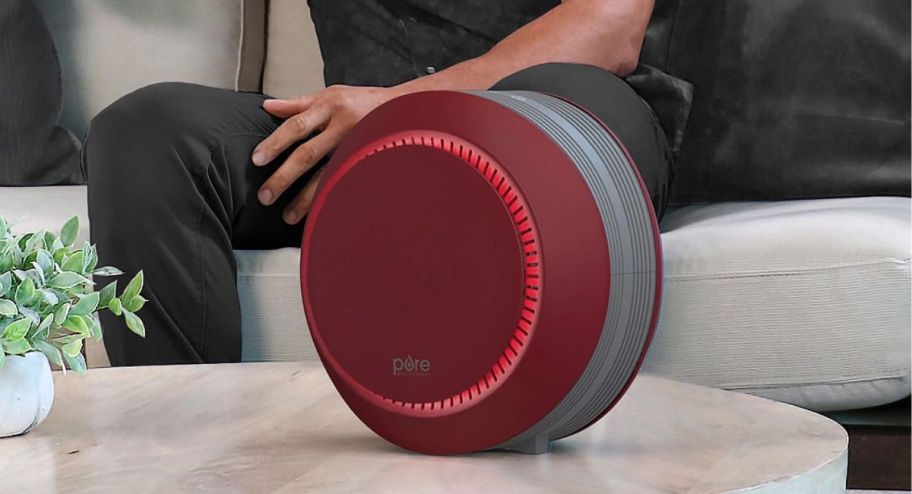 Air purifer siting on coffee table with man behind it