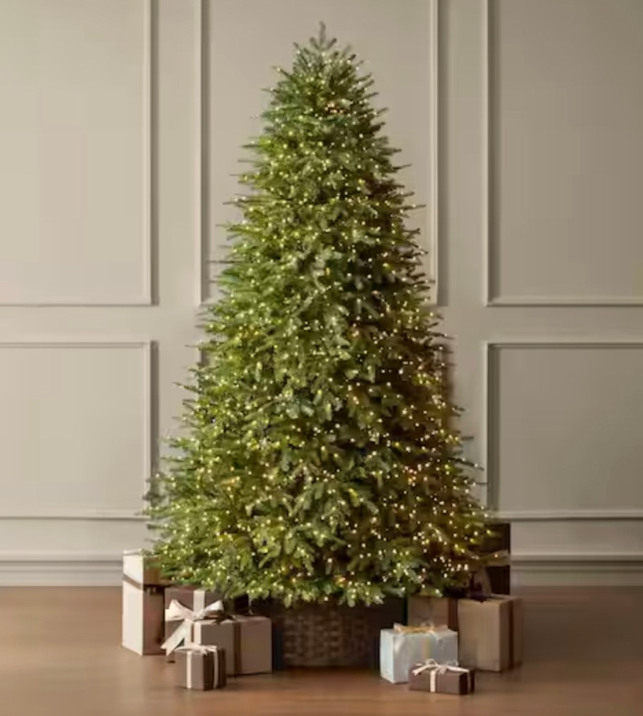 green lit christmas tree with neutral gifts under it