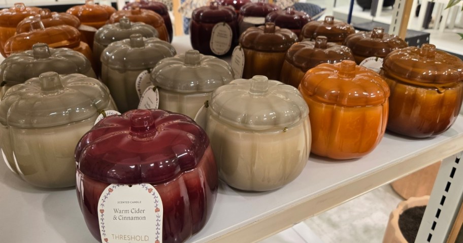 pumpkin shaped glass jar candles on a store shelf