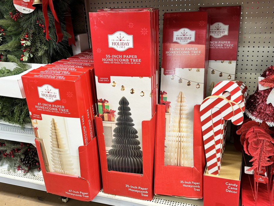 boxes of paper Christmas trees and other Christmas decor on a shelf at Walmart