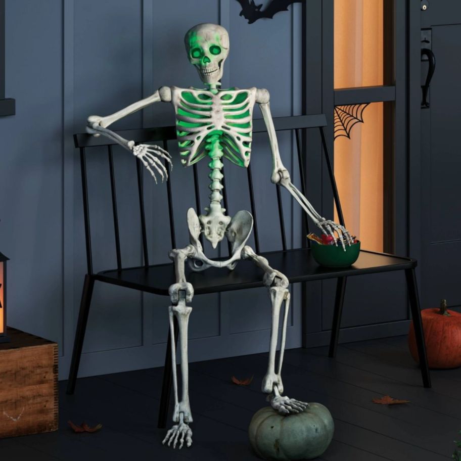  Lifesize Skeleton Halloween Decorative Prop with green eyes sitting on the porch
