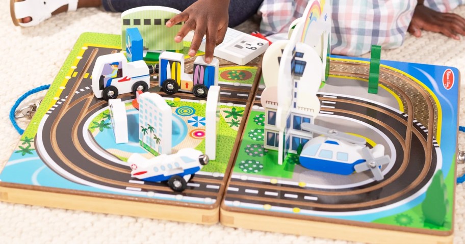 girl playing with a wooden airport playset