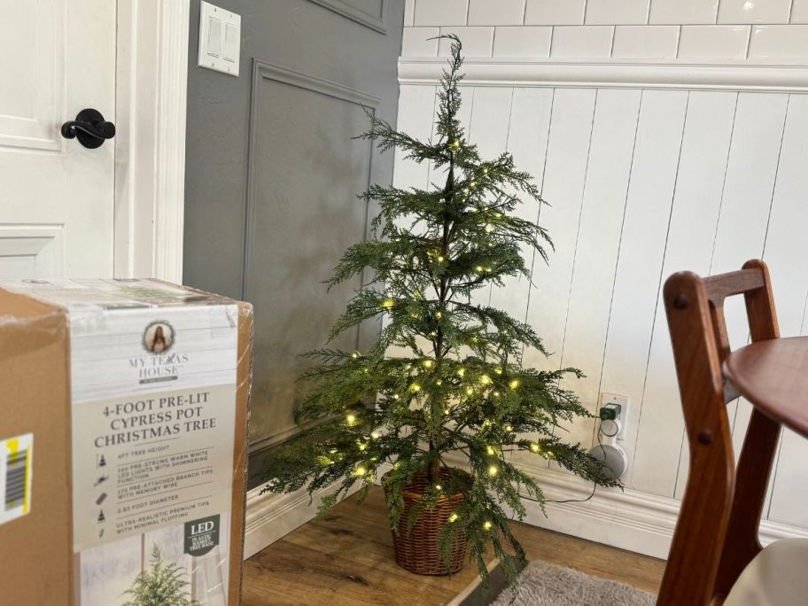 A 4-foot-tall lit tree in a dining room 