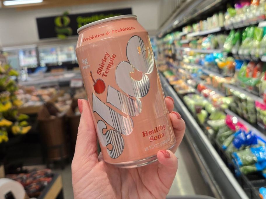 A person holding a pink can of Slice 