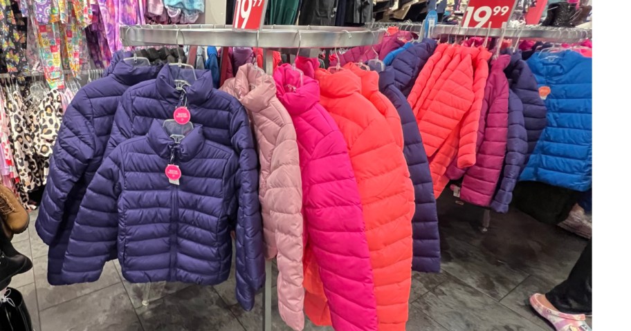 rack of colorful, children's place puffer jackets inside store