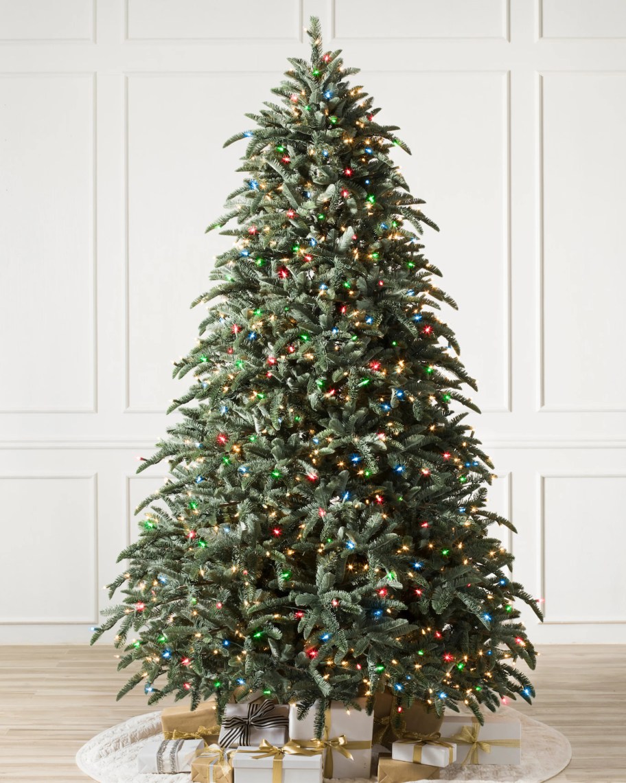 christmas tree with colored lights and gold and white presents