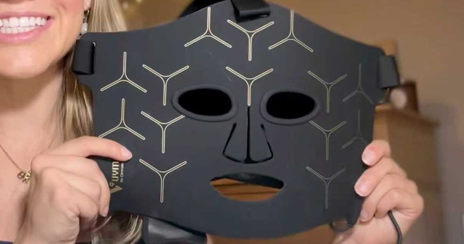woman holding red light therapy mask