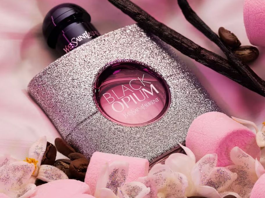 Yves Saint Laurent Black Opium with flowers around it