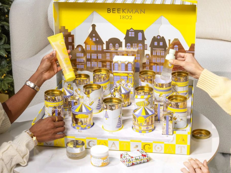 women picking up pieces of The G.O.A.T. 2025 Advent Calendar
