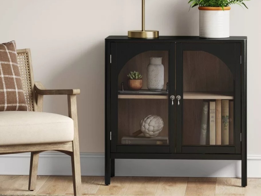 black 2 door cabinet shown with an accent chair