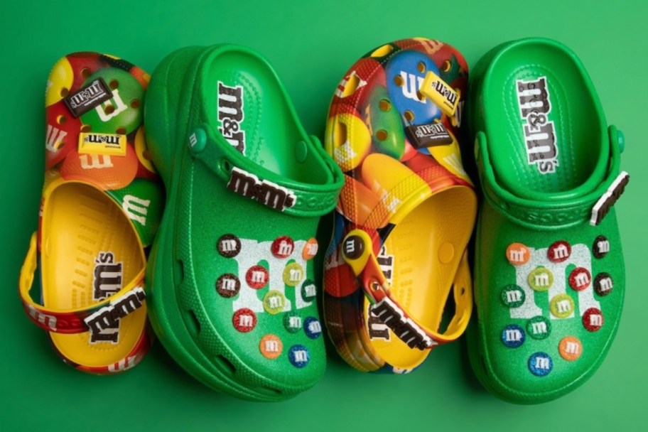 yellow and green m&m crocs laying on their sides in a pattern and green background