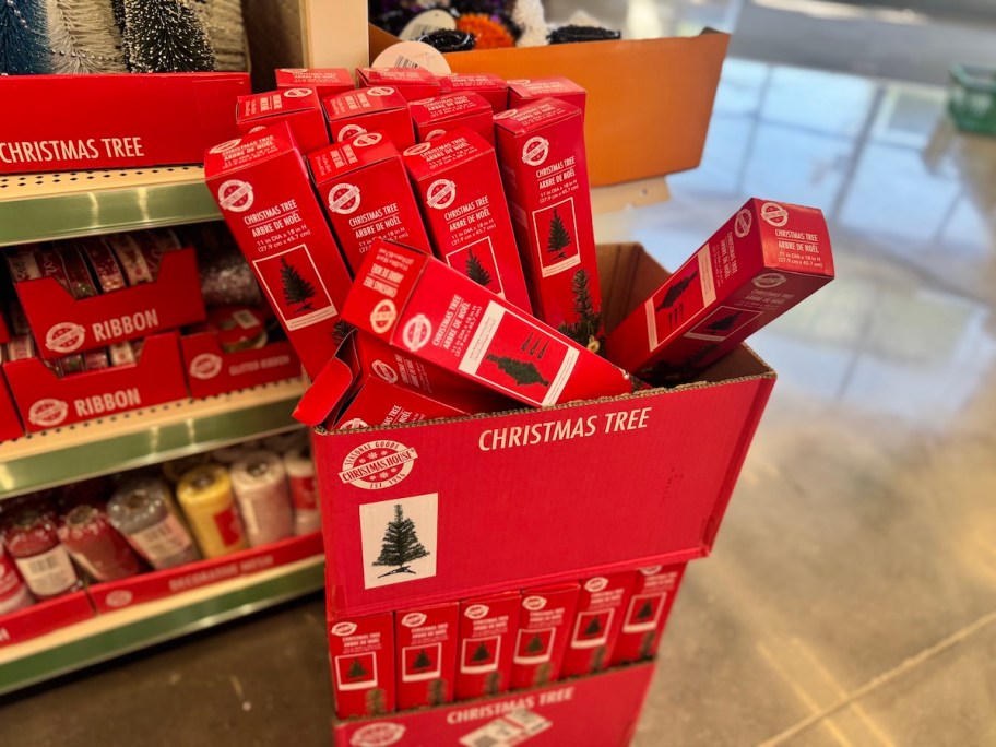 artificial christmas trees in boxes in store aisle