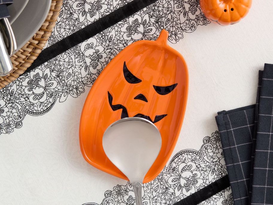 Pumpkin-Shaped Ceramic Spoon Rest with spoon on it on tablecloth