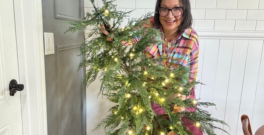 woman holding prelit christmas tree
