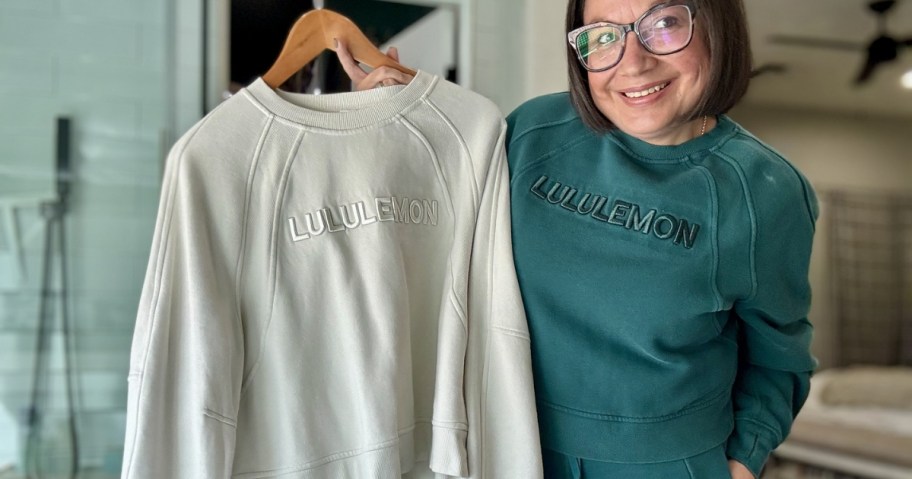 woman wearing and holding lululemon scuba oversized wordmark pullovers