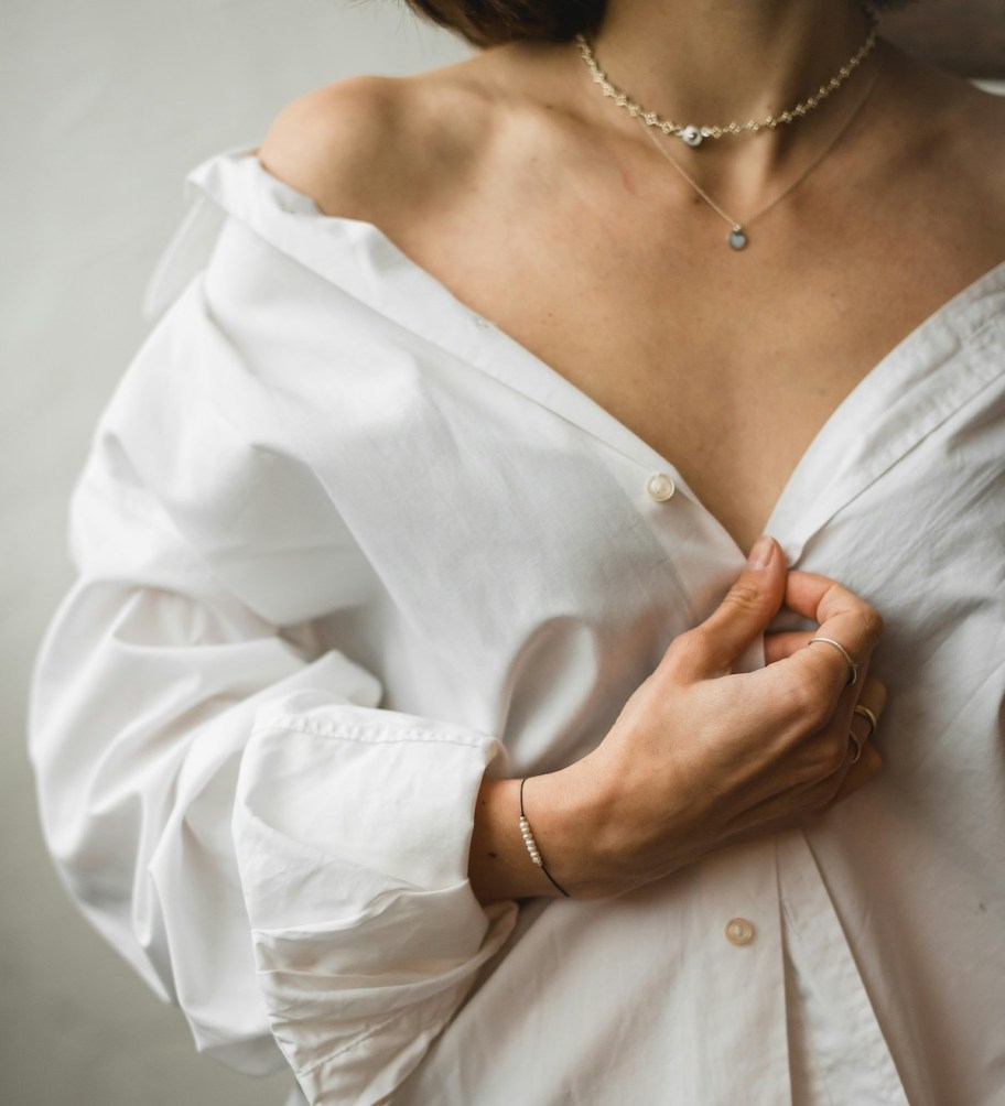 woman holding together white button down blouse