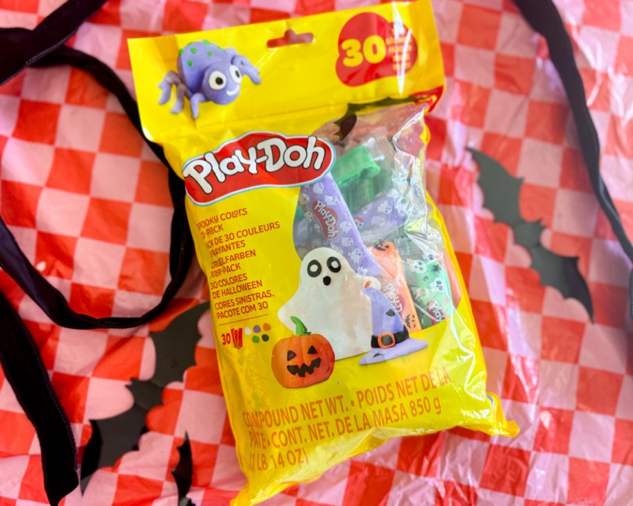 yellow bag of play doh sticks on pink and red checkered background