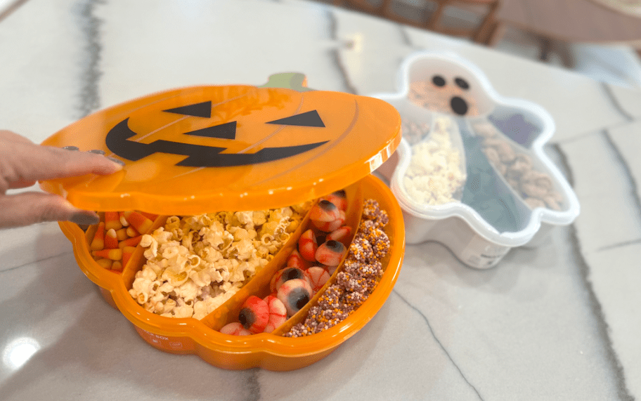 hand opening pumpkin snackle box on kitchen 