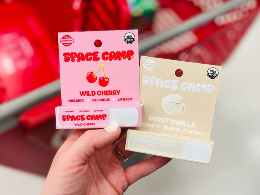 hand holding two space camp lip balms in different flavors