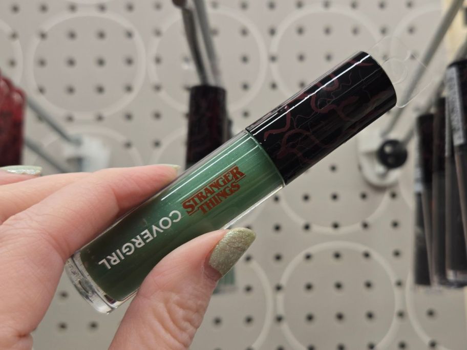 green COVERGIRL x STRANGER THINGS The Bite PH Transforming Lip Gloss in hand in store